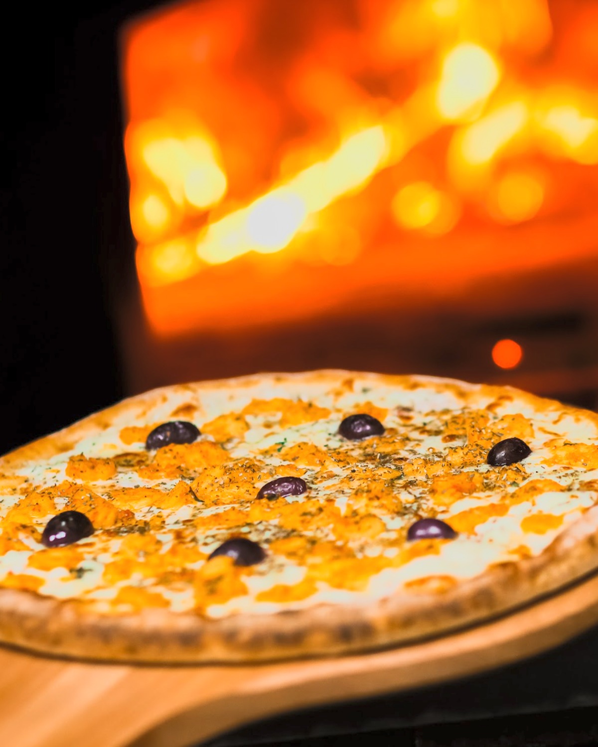 Pizza artesanal da Ituana diante da brasa